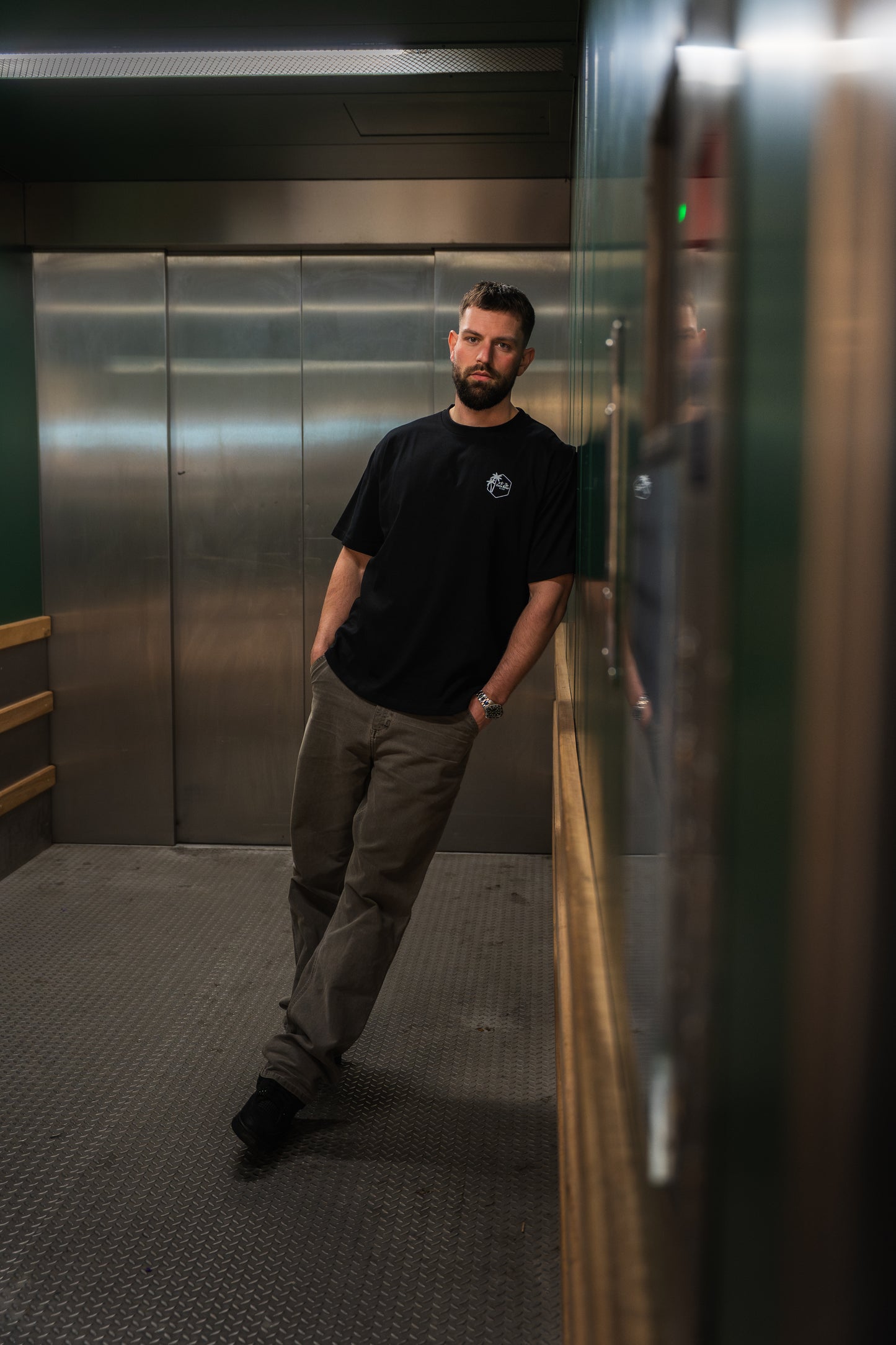 Model wearing The Island Edit Tee in Black, loose fit streetwear t-shirt with back graphic